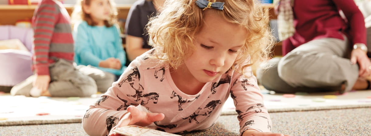 Little girl looking through a book