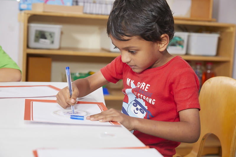 Child coloring at table