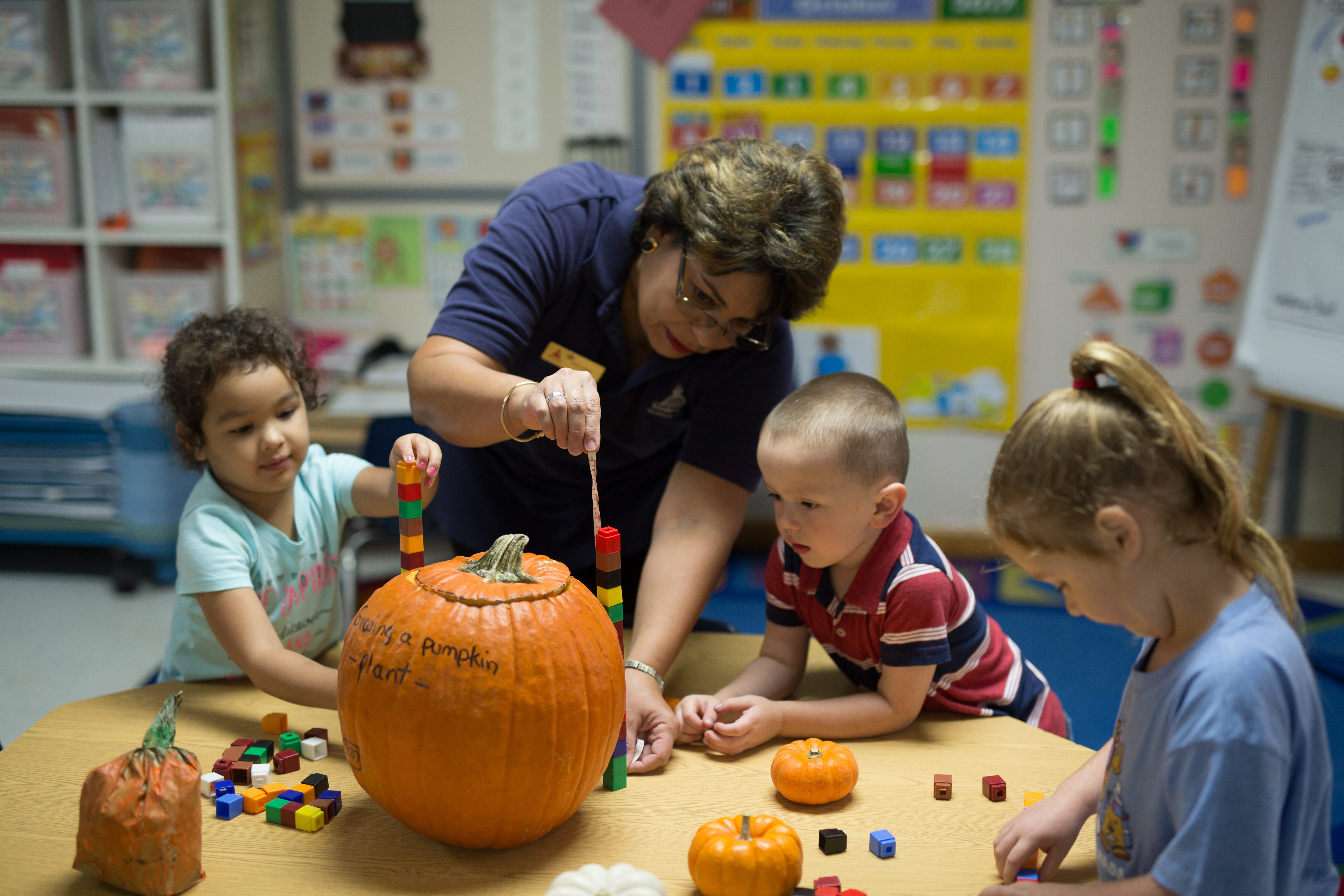 A pre-k teacher building blocks with classroom children