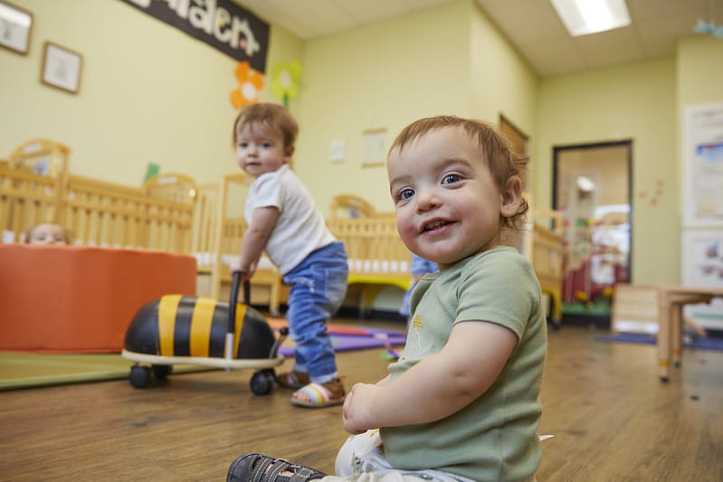 Two infants playing in a classroom