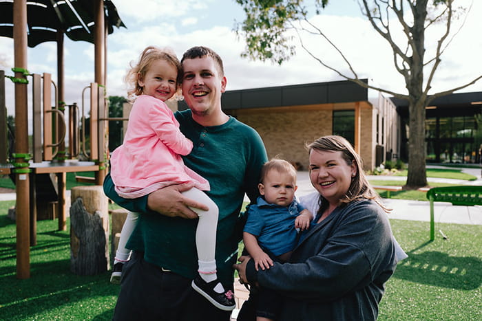 A family of four together on a playground