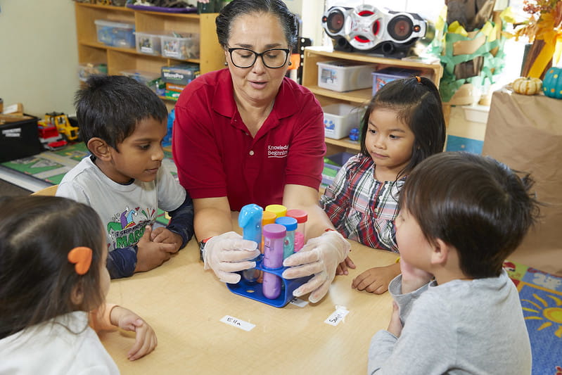 A teacher shows children a science experiment at a KinderCare Learning Center