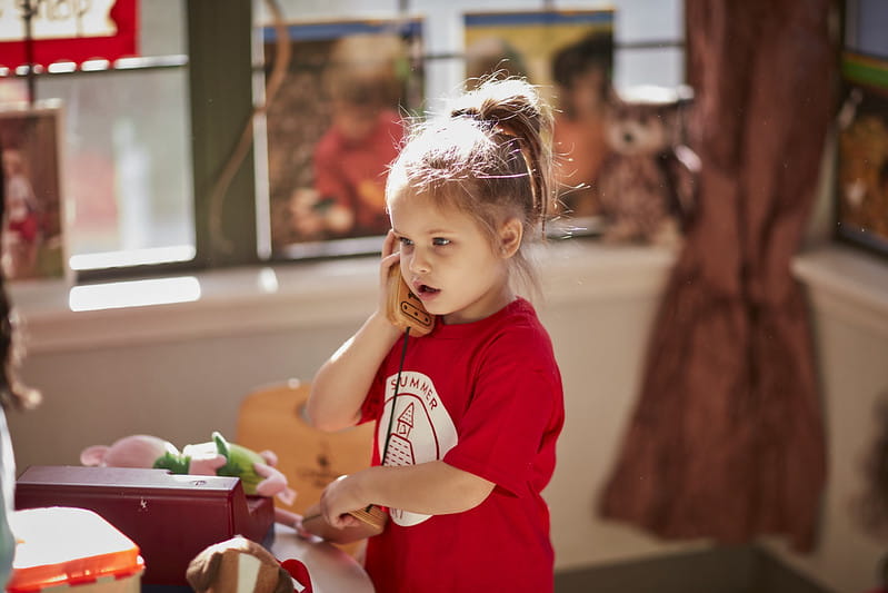 Little girl talking on pretend telephone