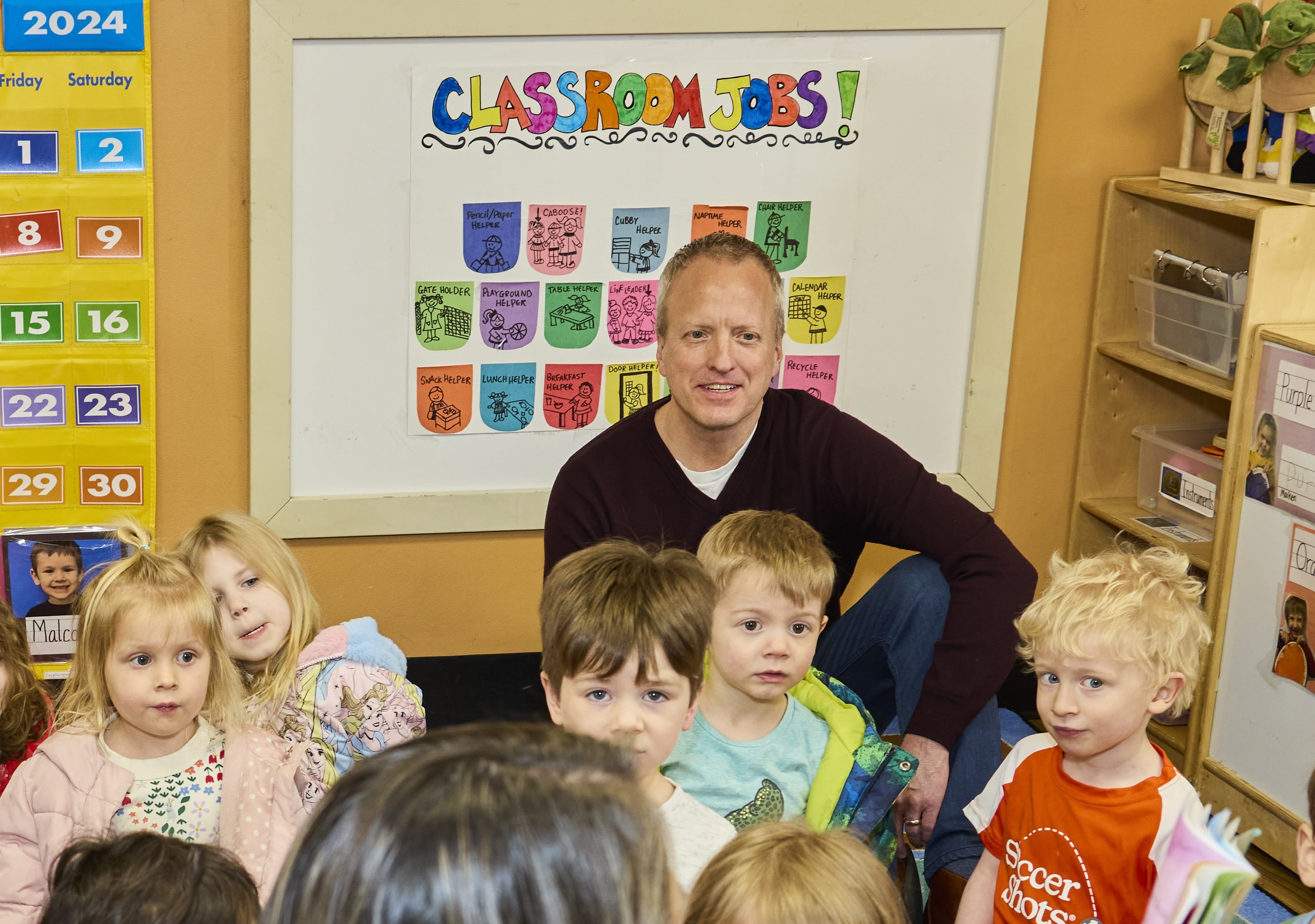 Adult sitting on floor with children